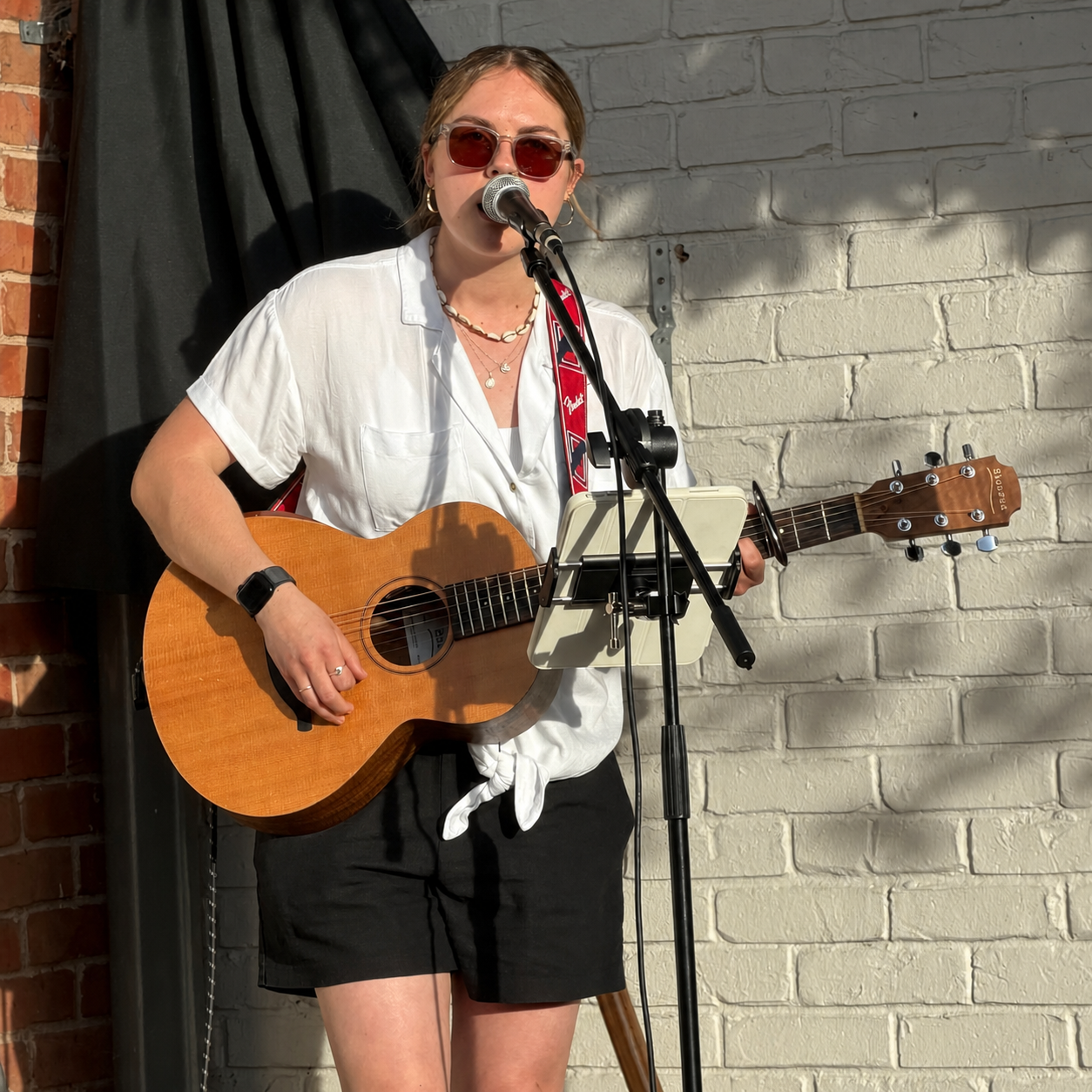 Liv Driver singing and playing acoustic guitar